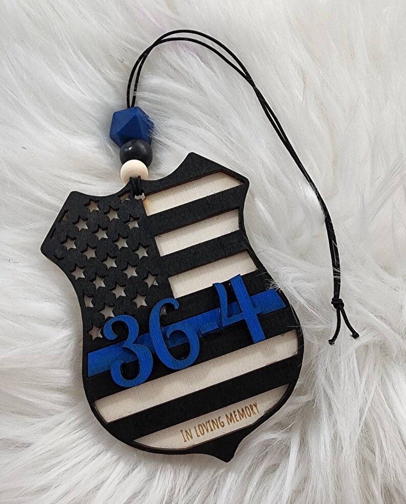May include: Wooden ornament shaped like a police badge with an American flag design, blue "364" number, and "In Loving Memory" text.