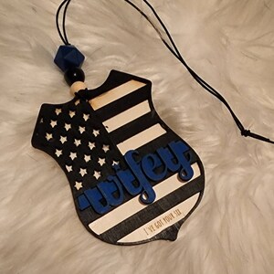 May include: Wooden car air freshener shaped like a police badge with an American flag design and the word "wifey" in blue lettering. The text "I've got your six" is printed at the bottom.