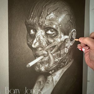 May include: A monochrome charcoal drawing of a man with exposed facial muscles, smoking a cigarette. The artwork is signed "Barry Jones". The drawing is in progress, with a hand holding a pencil, adding detail to the ear.