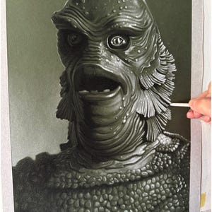 May include: A detailed charcoal or graphite drawing on textured paper depicting the creature from the black lagoon with prominent scales, gills, and a wide mouth. The artwork is signed Barry Jones in the bottom left corner in cursive script.