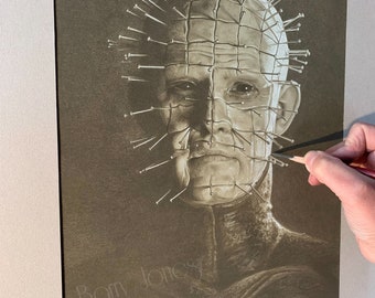 Può includere: Un disegno a matita in bianco e nero di un personaggio del film horror Hellraiser. Il personaggio ha una griglia di ganci e spilli di metallo sulla testa. Il disegno è firmato "Barry Jones".