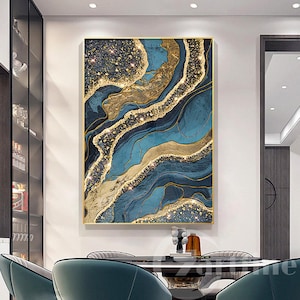 Könnte beinhalten: Abstrakter Wandkunstdruck mit einem blauen und goldenen Marmormuster mit glitzernder Textur. Der Druck ist in einem dünnen goldenen Rahmen gerahmt.
