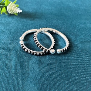 May include: Two silver bangles with black beads around the edge.