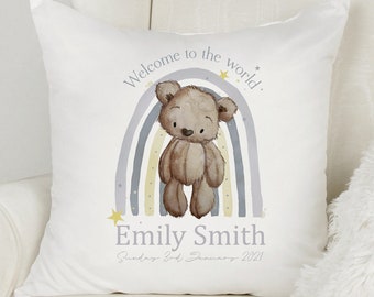 May include: White square pillow with a watercolor design featuring a brown teddy bear, a rainbow, and the text "Welcome to the world." Below the rainbow is the name "Emily Smith" and the date "Sunday 3rd January 2021."