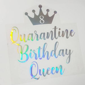 May include: A clear sticker with the words "Quarantine Birthday Queen" in a holographic script font. Above the text is a silver crown with the number 8 inside. The sticker is on a white background.