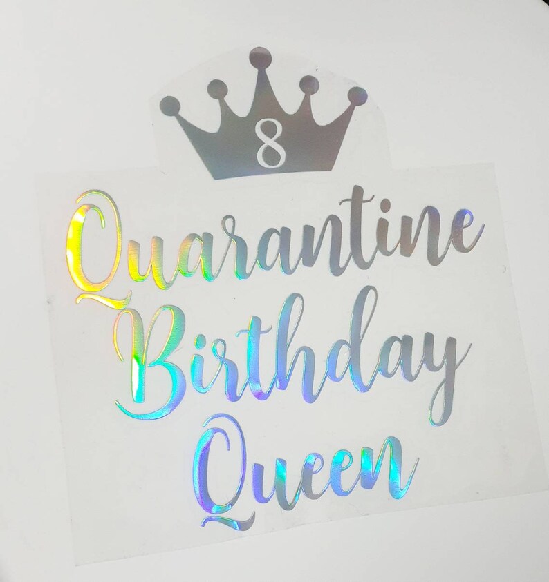 May include: A clear sticker with the words "Quarantine Birthday Queen" in a holographic script font. Above the text is a silver crown with the number 8 inside. The sticker is on a white background.