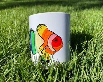 Gay Pride-fiskmugg [Mandalafisk med Pride-flagga på en vit keramikmugg med handtag]