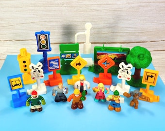 Lote de accesorios GeoTrax de Fisher Price: figuras, señales, árbol, semáforos, cruce de ferrocarril y piezas de juego.