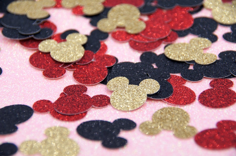 May include: A scattering of red, gold, and black glitter Mickey Mouse head confetti.