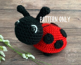 Könnte beinhalten: Gehäkelter Marienkäfer mit schwarzem Kopf und rotem Körper mit schwarzen Punkten. Der Marienkäfer hat große, runde Augen und zwei schwarze Antennen. Der Text "PATTERN ONLY" ist im Bild zu sehen.