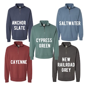 May include: Five different colored quarter-zip sweatshirts with white text. The colors are Anchor Slate, Cypress Green, Cayenne, Saltwater, and New Railroad Grey.