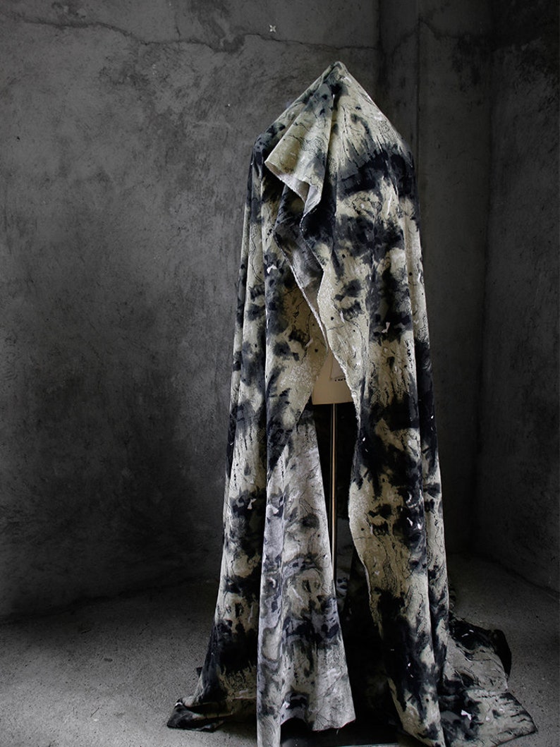 May include: A black and white patterned fabric draped over a mannequin. The fabric has a textured, abstract design.