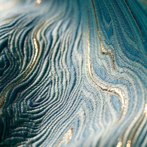 May include: Close-up of a teal blue fabric with a wavy, textured pattern and a subtle shimmer of gold thread.