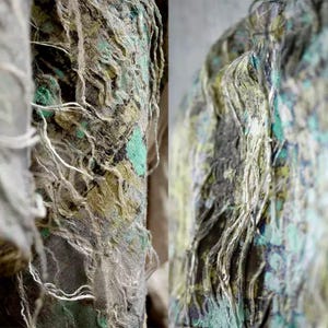 Könnte beinhalten: Nahaufnahme eines Stoffes mit ausgefranster Textur und einem abstrakten Muster in Grün-, Braun- und Weißtönen.