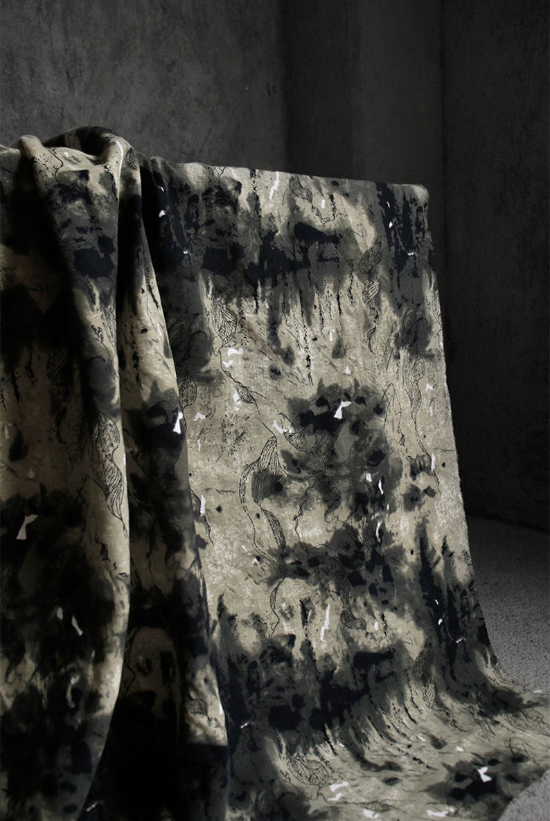 May include: Black and white abstract print fabric with a textured, linen-like feel. The fabric has a dark background with white and gray abstract shapes.