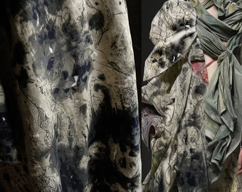 May include: A close-up of a fabric with a black and white abstract pattern. The fabric is draped over a surface and has a textured look.