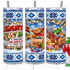 Puede incluir: Un vaso cilíndrico con pajita que presenta un patrón de copos de nieve azules y blancos. El centro muestra un gráfico de una juguetería con un oso de peluche y el texto "Santa's Toy Shop Making Children Happy Since 1799".