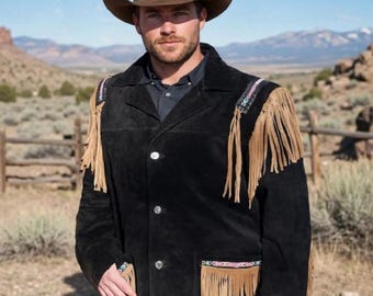May include: A black suede jacket featuring tan fringe detailing on the shoulders and pockets, accented with colorful patterned trim. The jacket has a collared neckline, a button-front closure, and long sleeves, worn with a brown cowboy hat.
