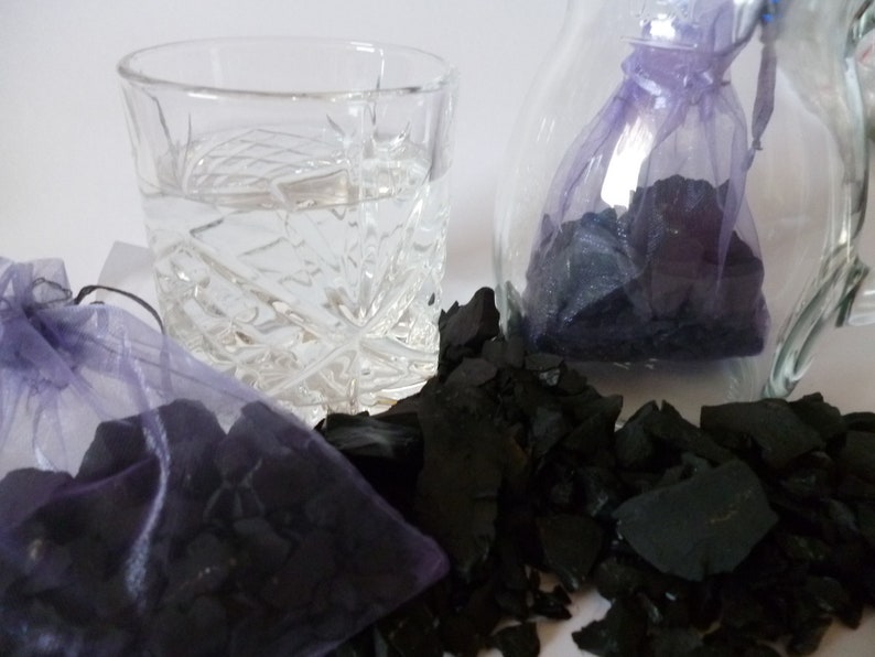 A post with 2 x 125 g = 1250 carat shungite raw from Russia distributed on two organzas\u00e4ckchen Wasserstein,Heilstein