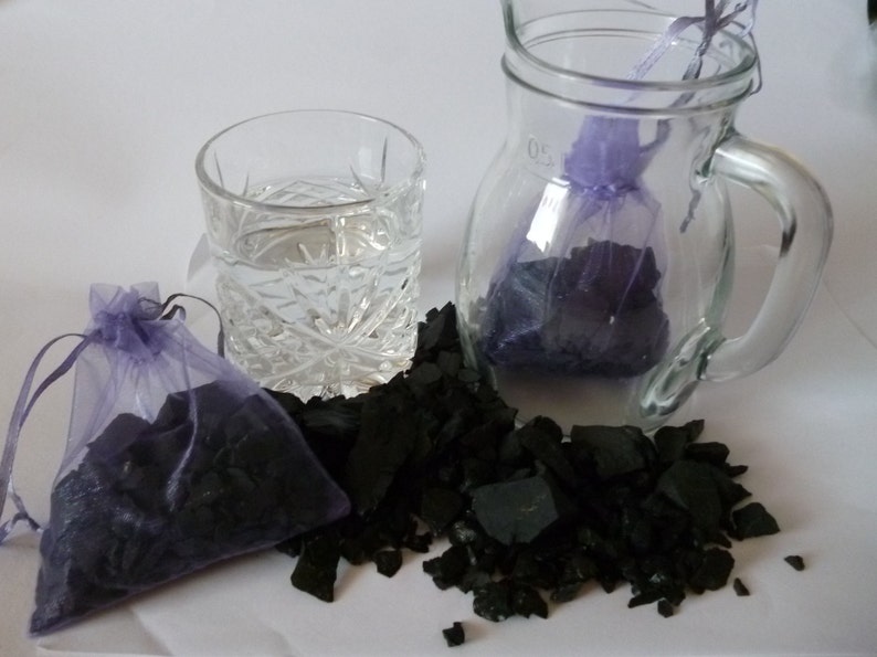 A post with 2 x 125 g = 1250 carat shungite raw from Russia distributed on two organzas\u00e4ckchen Wasserstein,Heilstein