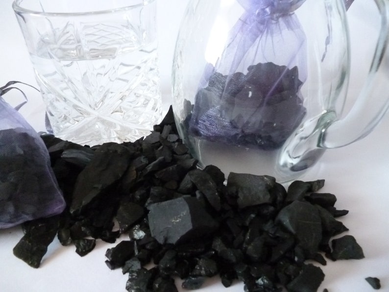 A post with 2 x 125 g = 1250 carat shungite raw from Russia distributed on two organzas\u00e4ckchen Wasserstein,Heilstein