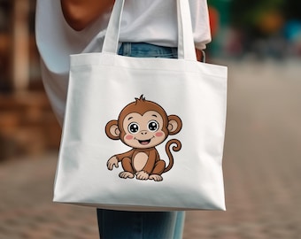 May include: White tote bag with a cartoon monkey design. The monkey is depicted in brown and tan tones, with big eyes and a smile. The bag is being held, with a blurred background suggesting an outdoor setting.