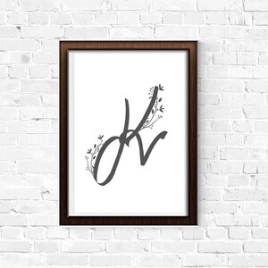 May include: A framed print featuring a black and white illustration of the letter "K" with floral embellishments.