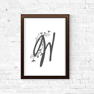 May include: A framed print with a black and white illustration of the letters "GW" with a floral design around the "G".