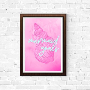 Puede incluir: Un fondo de acuarela rosa y blanco con un dibujo en blanco y negro de una concha. El texto "mermaid goals" está escrito en azul.