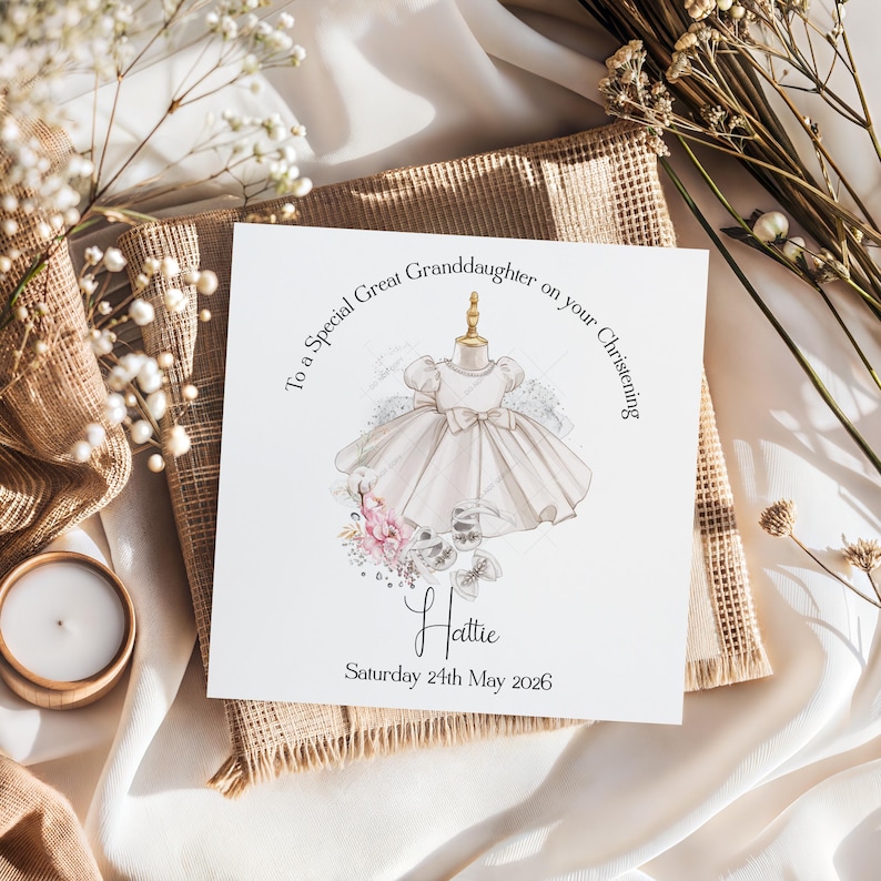 May include: A greeting card with a watercolor illustration of a baby dress on a mannequin. The card reads "To a Special Great Granddaughter on your Christening" and includes the name "Hattie" and the date "Saturday 24th May 2026".