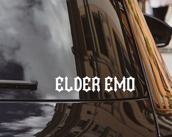 Puede incluir: Coche negro con una pegatina de vinilo blanco en la ventana trasera que dice "ELDER EMO".
