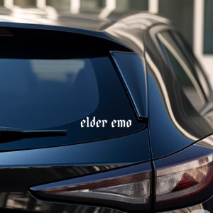 May include: A black car with a white sticker on the back window that says "elder emo".