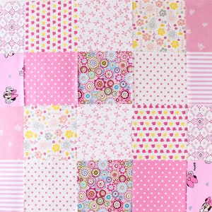 May include: A pink and white patchwork quilt with various patterns, including polka dots, flowers, and bows. The quilt features a Minnie Mouse design in the top left and bottom right corners.