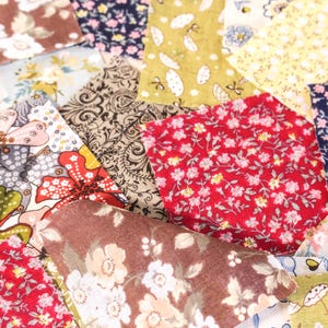 Pode incluir: Uma cole&ccedil;&atilde;o de retalhos de tecido coloridos com desenhos florais e estampados. Os retalhos apresentam v&aacute;rias cores, incluindo vermelho, castanho, amarelo e azul, com padr&otilde;es florais e paisley detalhados. Ideal para projetos de colchas ou artesanato.