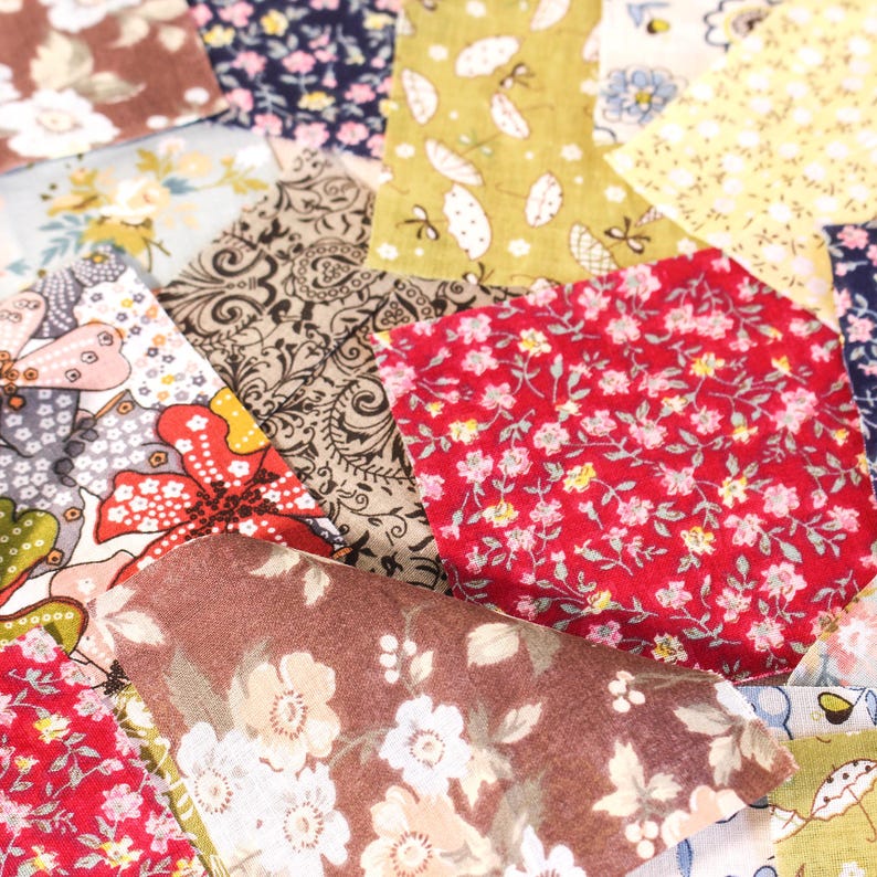 Pode incluir: Uma cole&ccedil;&atilde;o de retalhos de tecido coloridos com desenhos florais e estampados. Os retalhos apresentam v&aacute;rias cores, incluindo vermelho, castanho, amarelo e azul, com padr&otilde;es florais e paisley detalhados. Ideal para projetos de colchas ou artesanato.