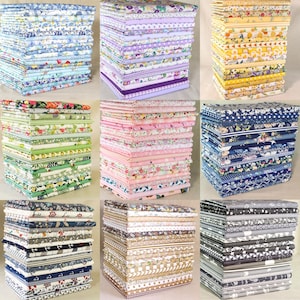 May include: Nine stacks of patterned fabric in various colors, including blue, purple, yellow, green, pink, and gray. Each stack is neatly folded, showcasing floral, nautical, and geometric designs. The fabrics appear to be cotton or a similar material, suitable for quilting or sewing projects.