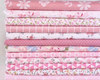 May include: A stack of pink fabric featuring diverse patterns such as flowers, polka dots, bows, and geometric designs. The fabrics are in light and medium pink hues, forming a coordinated and attractive collection. Suitable for sewing and craft projects.