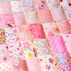 Peut inclure: Un assemblage de carrés de tissu roses avec divers motifs, tels que des fleurs, des pois et des motifs géométriques. Les tissus sont disposés en grille, présentant une variété de textures et de nuances de rose.
