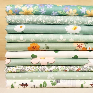 May include: A stack of 10 fabric squares with various floral and nature-themed patterns in shades of green, white, and orange. The fabric squares are made of cotton and are perfect for quilting, crafting, and other sewing projects.