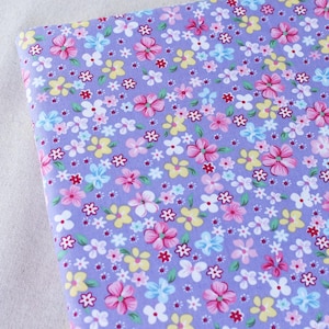 Puede incluir: Tela morada con un peque&ntilde;o estampado floral en rosa, amarillo, azul y blanco.