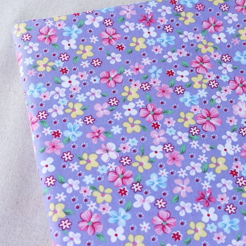 Puede incluir: Tela morada con un peque&ntilde;o estampado floral en rosa, amarillo, azul y blanco.