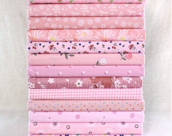 May include: A collection of pink fabric rolls featuring diverse patterns, including floral and polka dots. The pink hues vary from pale to medium shades, with designs such as daisies, small flowers, and gingham checks. The fabrics are neatly folded and stacked, ready for use.
