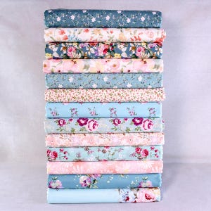 Pacote com 13 retalhos de tecido de algodão nas cores verde e rosa, perfeitos para patchwork e costura. Ideal para projetos de patchwork e artesanato.