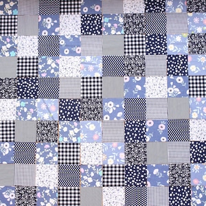 May include: A patchwork fabric with a variety of blue and white patterns, including floral, polka dot, gingham, and stars.