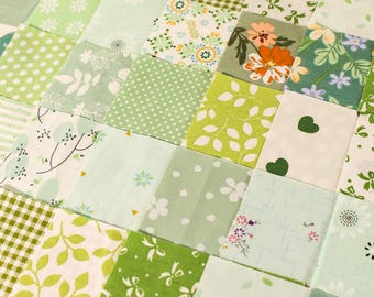 May include: A patchwork quilt made of various green and white fabrics with different patterns, including leaves, polka dots, hearts, and floral designs.
