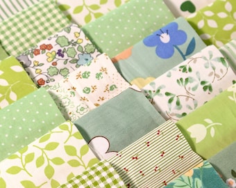 May include: A collection of green fabric squares with various patterns, including polka dots, gingham, floral, and leaves.