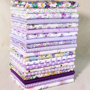 Può includere: Una pila di 20 quadrati di tessuto viola e bianco con vari motivi floreali, a pois e a righe. Il tessuto è perfetto per il quilting, l'artigianato e i progetti di cucito.