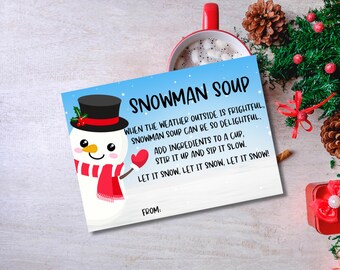 May include: A printable snowman soup recipe card with a cute snowman illustration. The card has a blue background with white snowflakes and red text that reads "Snowman Soup". The text says "When the weather outside is frightful, snowman soup can be so delightful. Add ingredients to a cup, stir it up and sip it slow. Let it snow, let it snow, let it snow!"