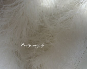 May include: White ostrich feathers, soft and fluffy, perfect for crafting or decorating.  The feathers are shown in a close-up view, highlighting their delicate texture.  "Party supply" is written in white text on the feathers.