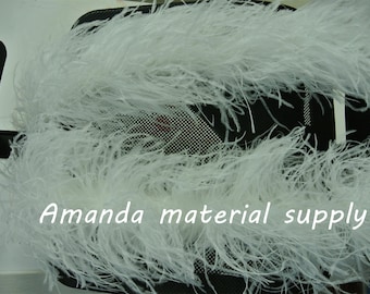 May include: A white ostrich feather boa. The boa is on a black chair with a mesh back. The text "Amanda material supply" is visible in the image.